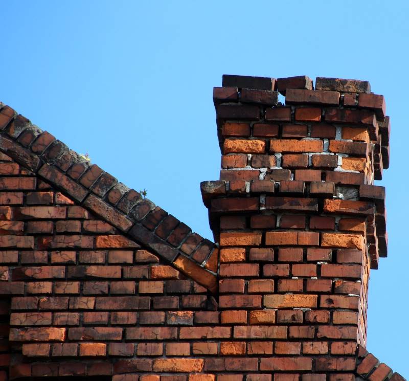 Signs Your Norwood Home Needs a Chimney Inspection Blog Article - Damaged chimney on an Norwood home showing cracks and missing mortar